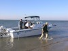 SundownIsland > A new crew arrives. Linda Barley (ski cap) and Lynn Travis prepare to follow Chester Smith to shore.  Dave Barley (baseball cap) gets ready to go pick up another group of volunteers. (Photo credit: Steve Tripp)
