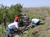 SundownIsland > Dale Blakeman, Brenda Eskelson and Jennifer White plant new trees while Abe Moore (red shirt) films. (Photo credit: Hannah Olson)