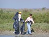 SundownIsland > Nicole Janek (L) and Monique Wells walk the perimeter of the island to pick up trash that could be harmful to the birds. (Photo credit: Hannah Olson)