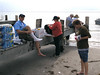 SundownIsland > Devon volunteers Jim Schuelke, Brenda Eskelson, and Barbara Van Horn change into dry footwear after wading ashore.  (photo by Steve Tripp)