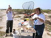 SundownIsland > Lynn Travis suggests that the wooden shoe sole she is holding could be used to start plant seedlings.  Molly Eskelson looks on.  (photo by Steve Tripp)