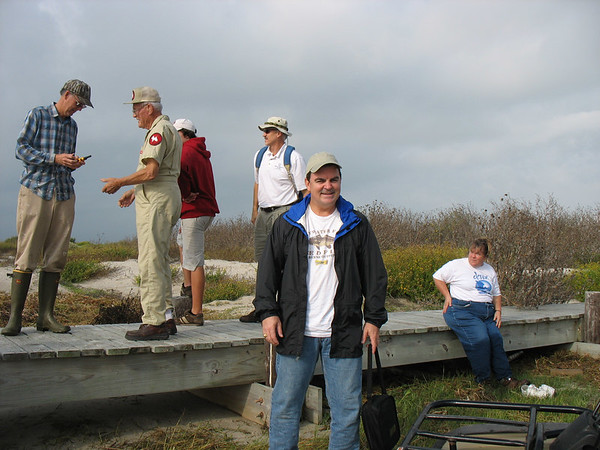 SundownIsland > Volunteers gather at the dock area to get organized. (photo by Peggy Wilkinson) (On the dock, eft to right: Ed Taylor, Chester Smith, Liam Parker and Dad, Bill Parker; in front, Tim Wilkinson and LynnTravis).