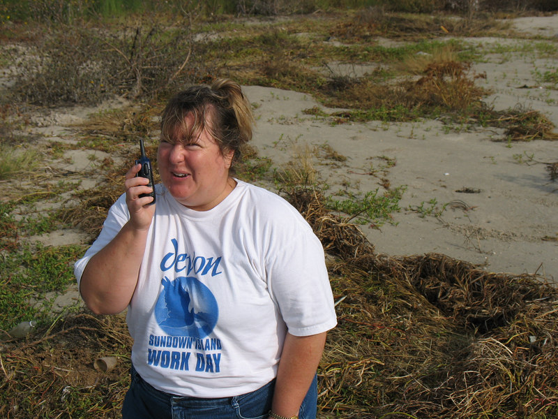 SundownIsland > Lynn Travis (Devon) tries out the walkie talkies used to communicate with other volunteers. (photo by Peggy Wilkinson)