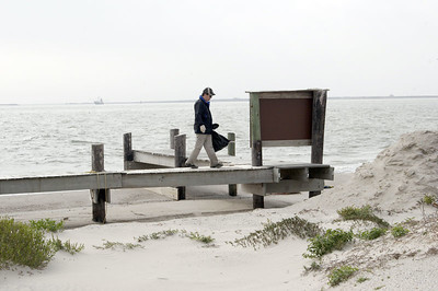 SundownIsland > Tim Wilkinson, Chester Smith's son-in-law, crosses over the sanded-in dock as he works on the beach clean-up.  (Photo credit: Marcy Spears)