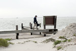SundownIsland > Tim Wilkinson, Chester Smith's son-in-law, crosses over the sanded-in dock as he works on the beach clean-up.  (Photo credit: Marcy Spears)