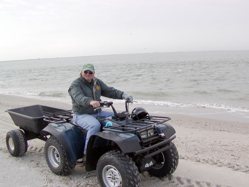SundownIsland > Rob Muir (Government Land Office) unloads the four-wheeler and prepares to move supplies to the shed and then to pick up bagged trash from the beach clean-up. (Photo credit: Rebeka Olson)