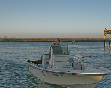 SundownIsland > Nancy Posey pulls up at Clark's Restaurant in her boat , the Pelican, to pick up volunteers for the ride out to Sundown Island.  As you can tell, it was a bit chilly early that morning.  Photo credit: Marcy Spears