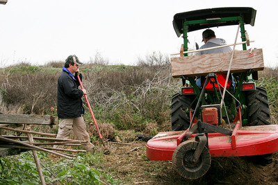 Tim moves more debris to the pile while Jackie moves some of the larger trash with the tractor.
Photo credit: Marcy Spears