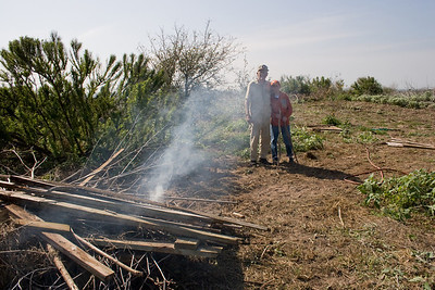 After Chester started the fire to burn off lumber and brush, he stands back with Jeremy King to watch his fire.
Photo credit: Marcy Spears
