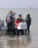 SundownIsland > Devon volunteer Brenda Eskelson wades ashore with lunch supplies for the group.  (photo by Steve Tripp)